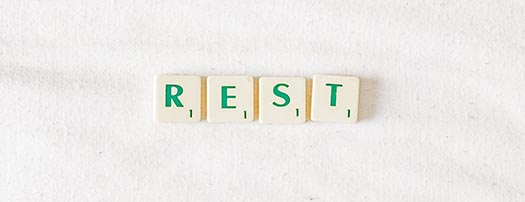 the word rest spelled out in green scrabble tiles